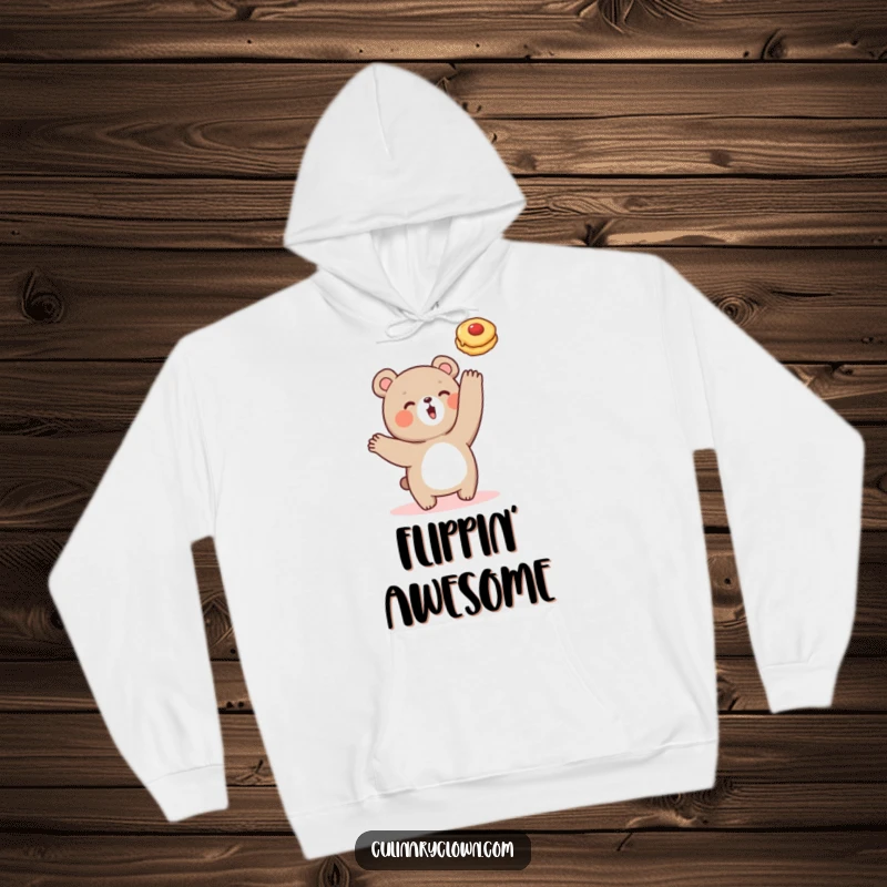 Funny hoodie with a cute bear character energetically flipping a pancake, perfect for cozy, humorous moments.
