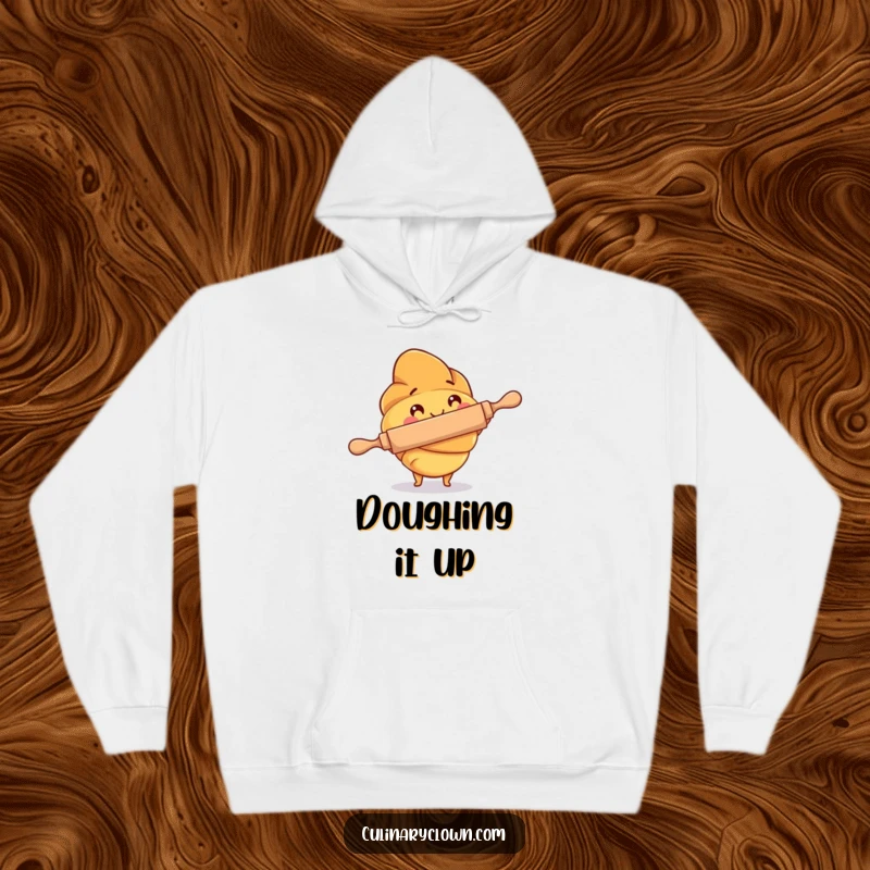 Funny Hoodie featuring a croissant character diligently using a rolling pin, offering warmth and baking-themed humor.