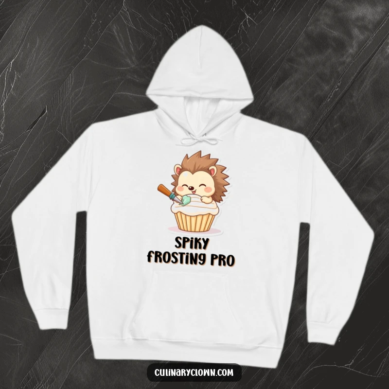 Funny hoodie with a smiling hedgehog expertly frosting a cupcake, symbolizing warmth and baking joy.