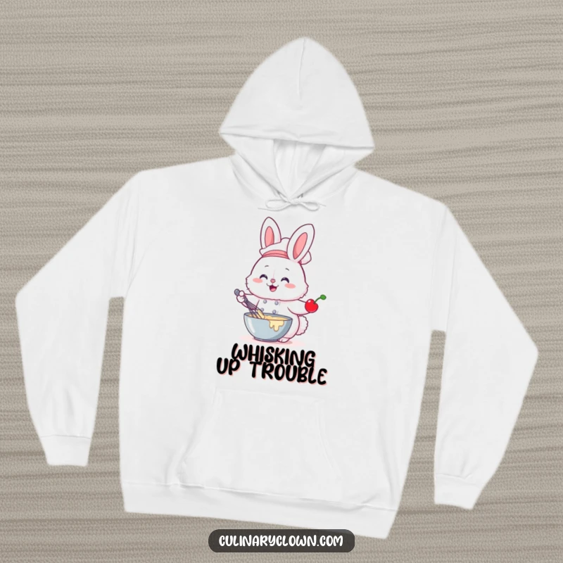 Funny hoodie showing a fluffy bunny chef whisking batter with a cherry, ideal for cozy baking sessions.
