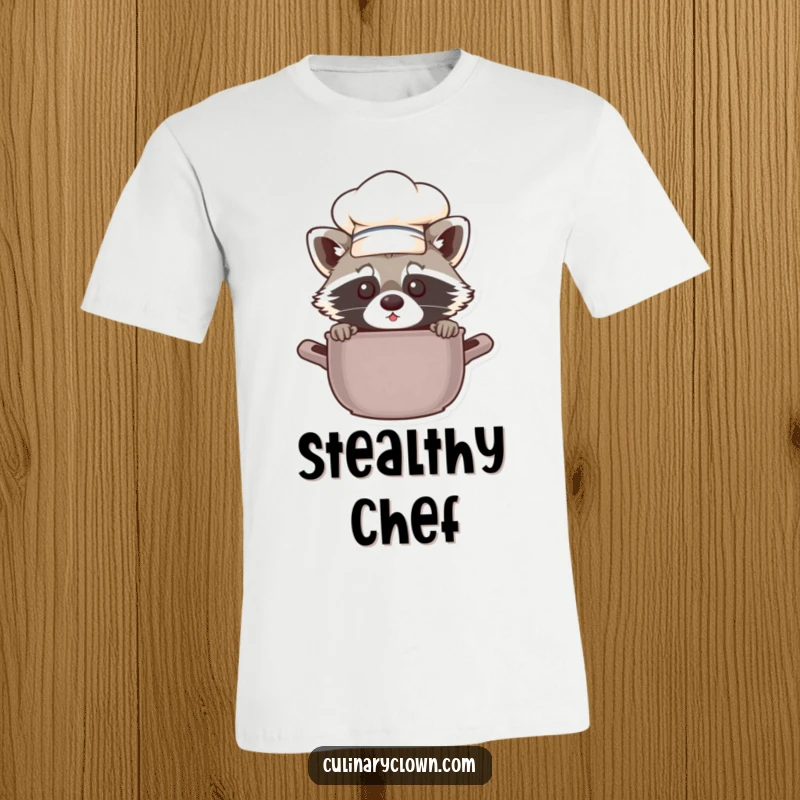 Funny chef raccoon peeking cheekily from behind a pot, a hilarious and comfortable graphic tee for food lovers.